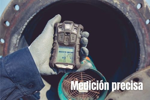 Trabajador con guante sostiene un detector de gases portátil en campo